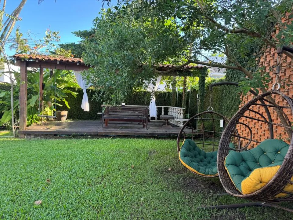 Jardim com pergolado e balanços da Pousada Point Beach Acácias